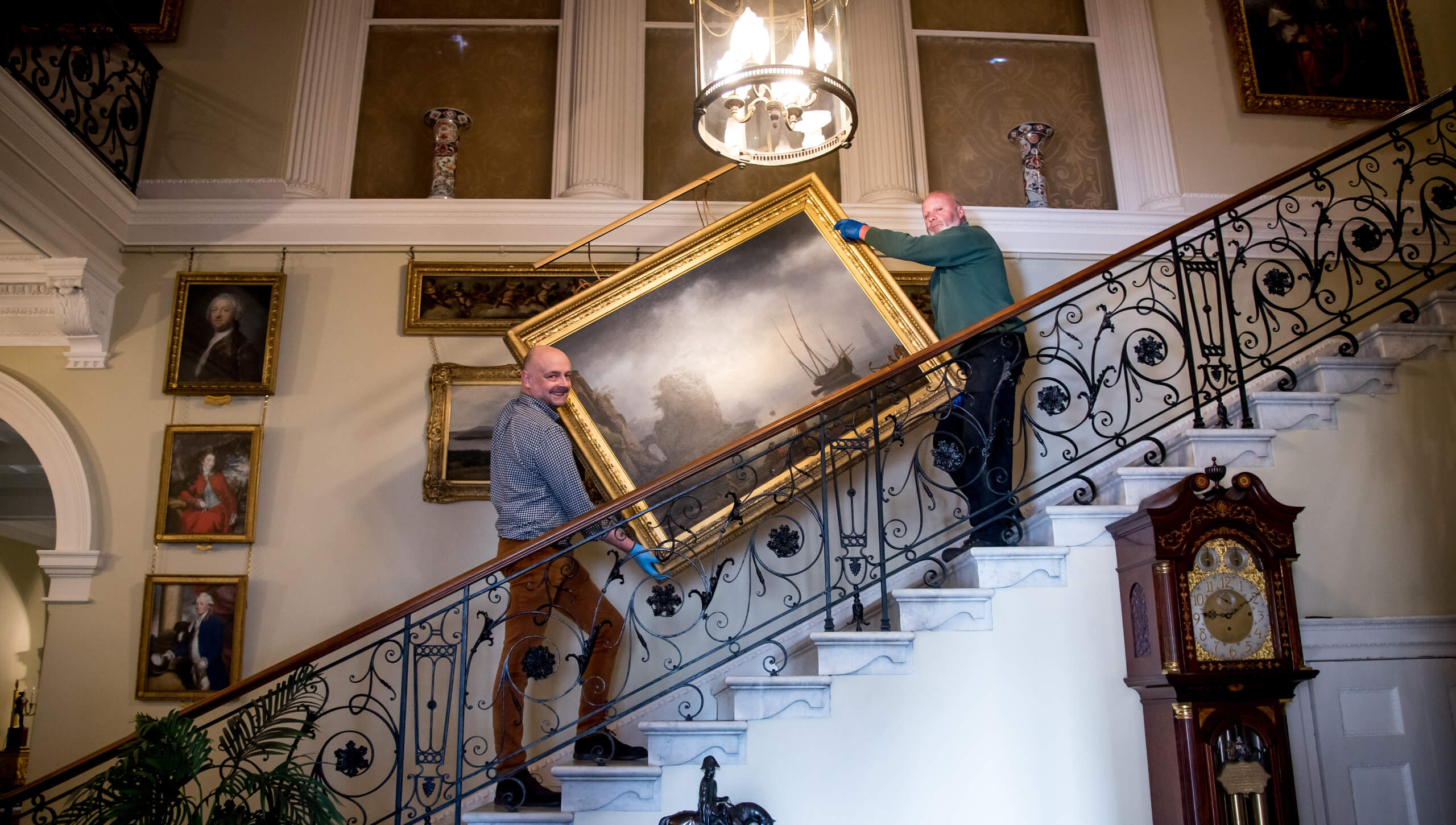 Pictured two work men carrying a large framed picture, carring it up a grand staircase as part of the restoration work on the Salons at Weston Park, the stately home on the Shropshire \ Staffordshire border has put a significant work by George Stubbs at the heart of the rooms.